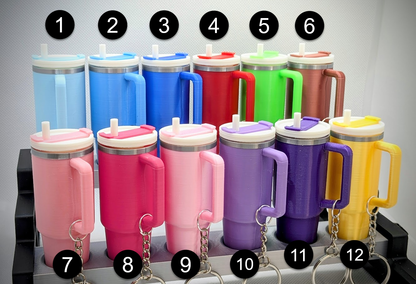 Set of colorful tumblers with handles and keychains on a gray background